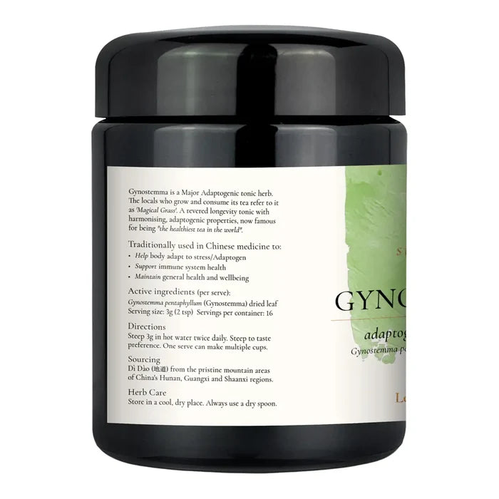 A black herbal tea jar with a black lid and a white label featuring green accents and text.