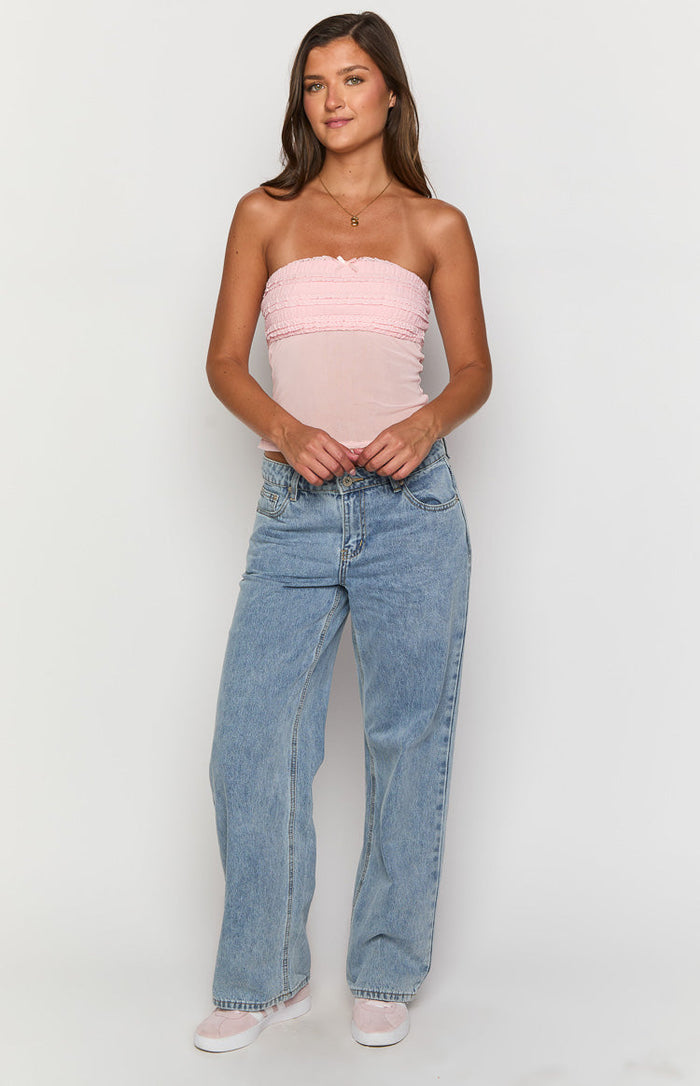Front view of a sheer pink strapless top with a ruffled shirred bust and fitted mesh body