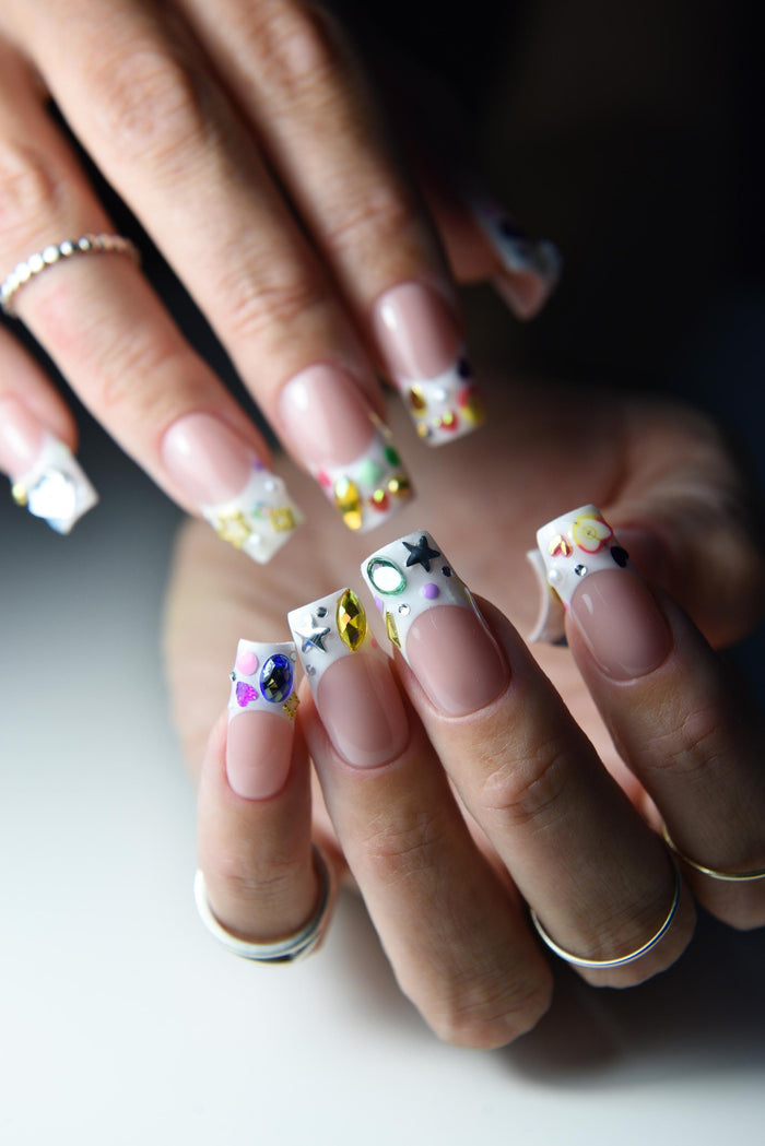Nude pink French press-on nails with colourful gems and painted tip details