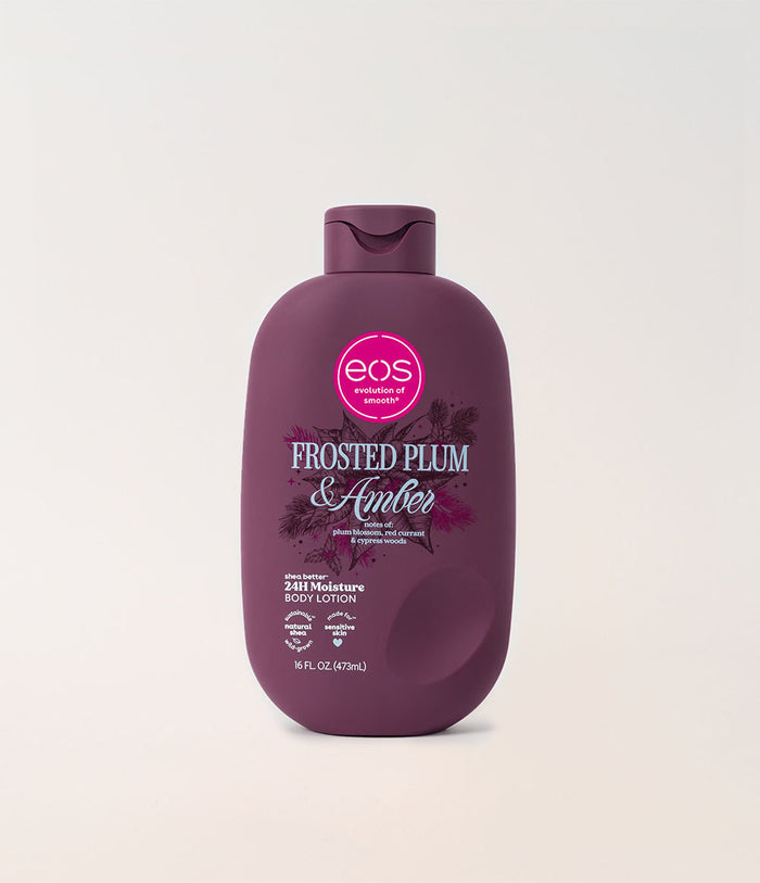 A bottle of EOS Enriched Body Lotion in the 'Frosted Plum & Amber' scent, shown on a clean, light off-white background. The bottle is a deep plum purple with a matching flip-top cap, featuring a pink circular EOS logo on the front.