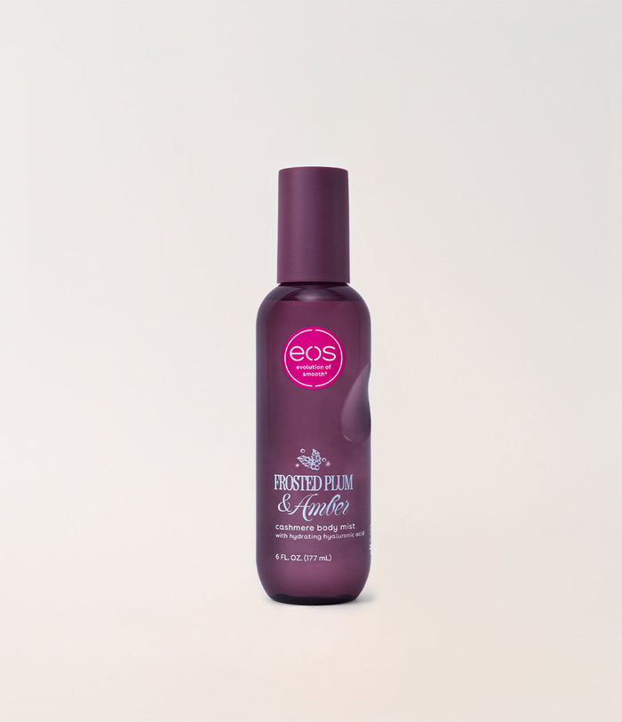 A bottle of EOS 'Frosted Plum & Amber' cashmere body mist, featuring a dark plum purple bottle and cap with a pink circular logo, set against a clean off-white background.