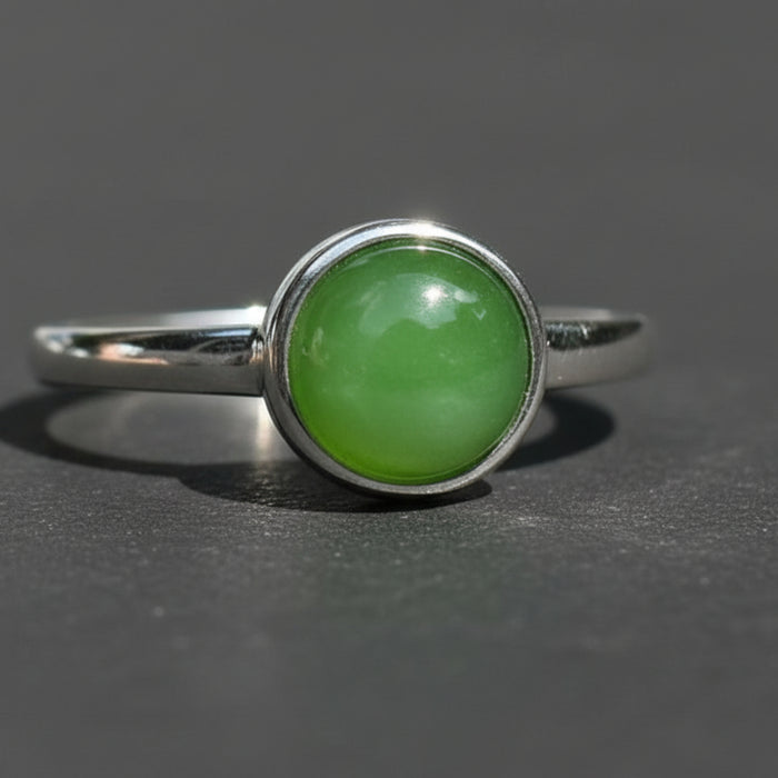 Green gemstone ring on a wooden surface