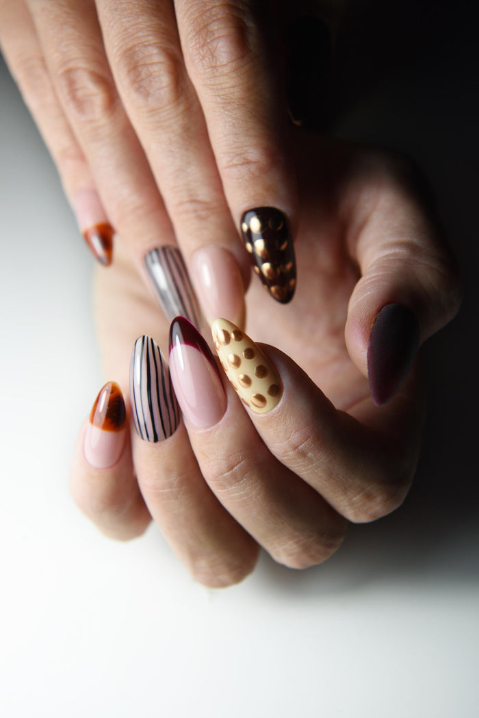 Mixed-media press-on nails with tortoise details, stripes and dimensional accents