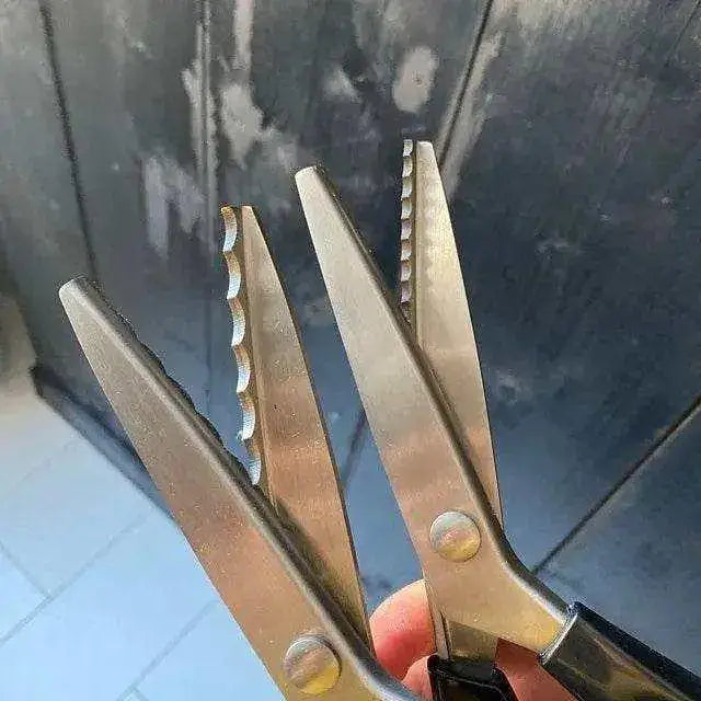 Professional stainless steel pinking shears with black soft-grip handles and a zig-zag blade.