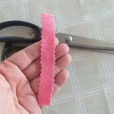 High-quality tailors pinking shears being used to cut a decorative edge on cotton fabric.