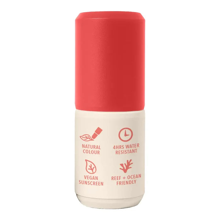 A cylindrical sunscreen bottle with a vibrant coral-red cap and a cream-colored lower body, featuring red text and icons highlighting product features.