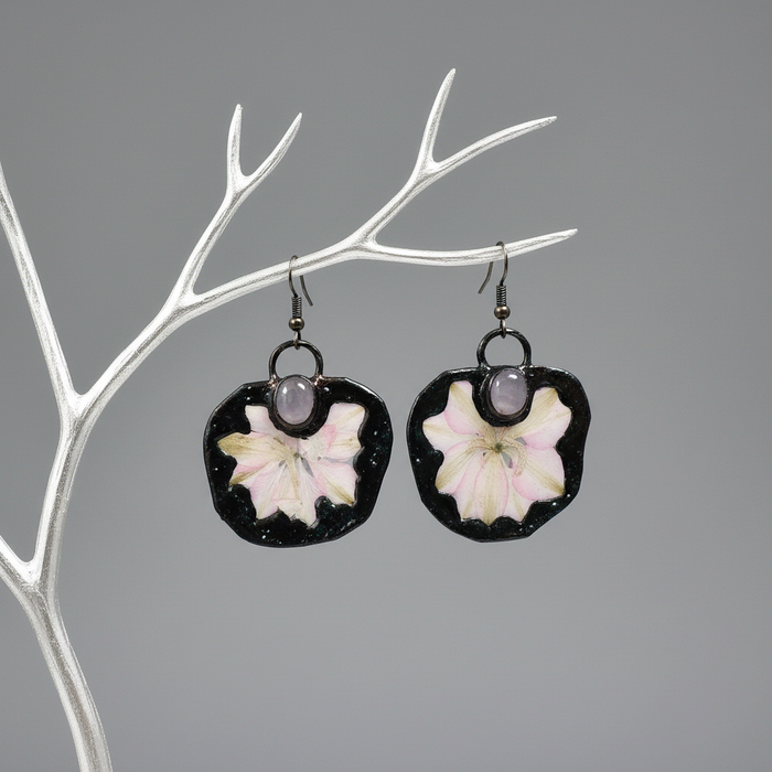 Pair of earrings with floral design on a gray background