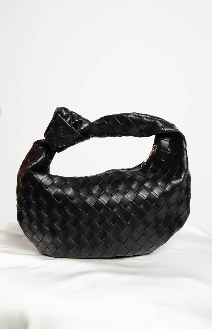 a black woven leather bag with a tie in the strap