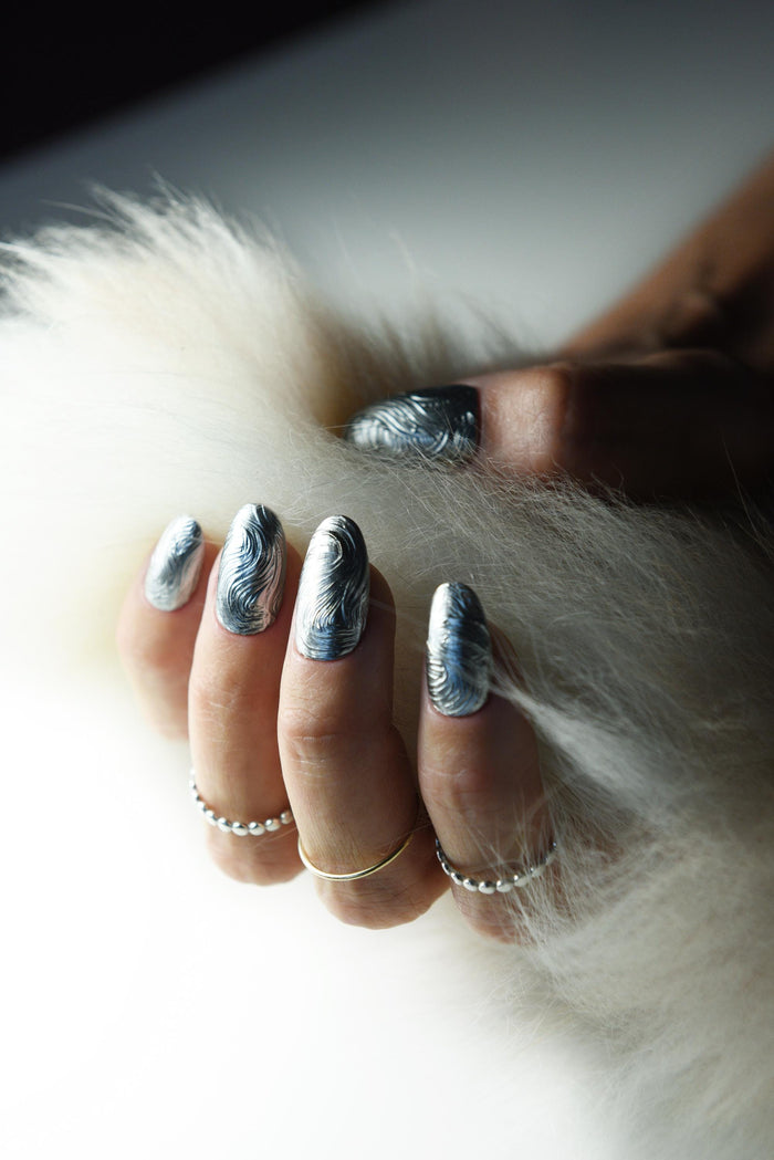 Sculpted silver chrome swirl press-on nails with a molten metal effect – detail view