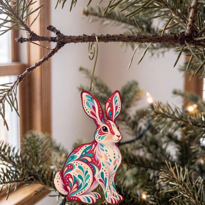 Laser-cut maple wood Snowshoe Hare folk art ornament O280 hanging on a fir branch, made in USA