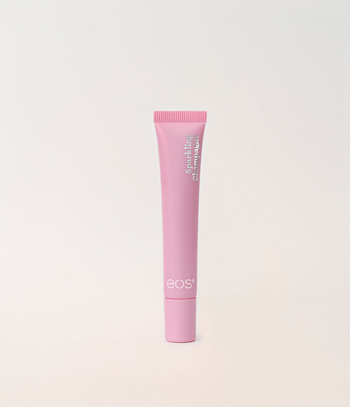 A pink squeeze tube of EOS lip shine against a clean, off-white background.