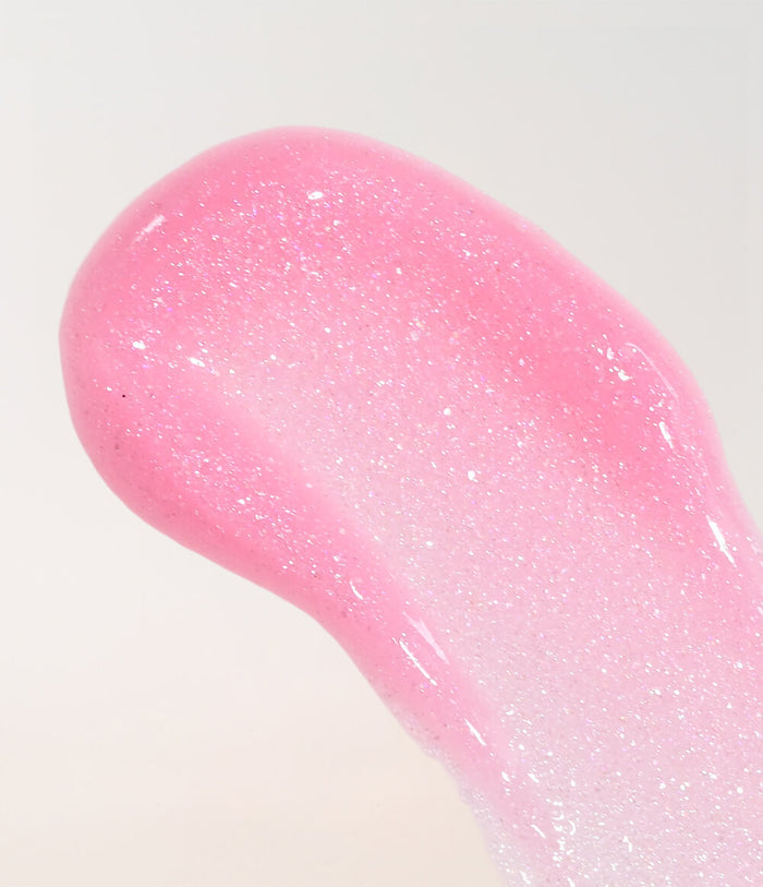A close-up of a glossy pink cosmetic swatch with fine shimmer, likely a gel or cream product texture, on a plain light background.