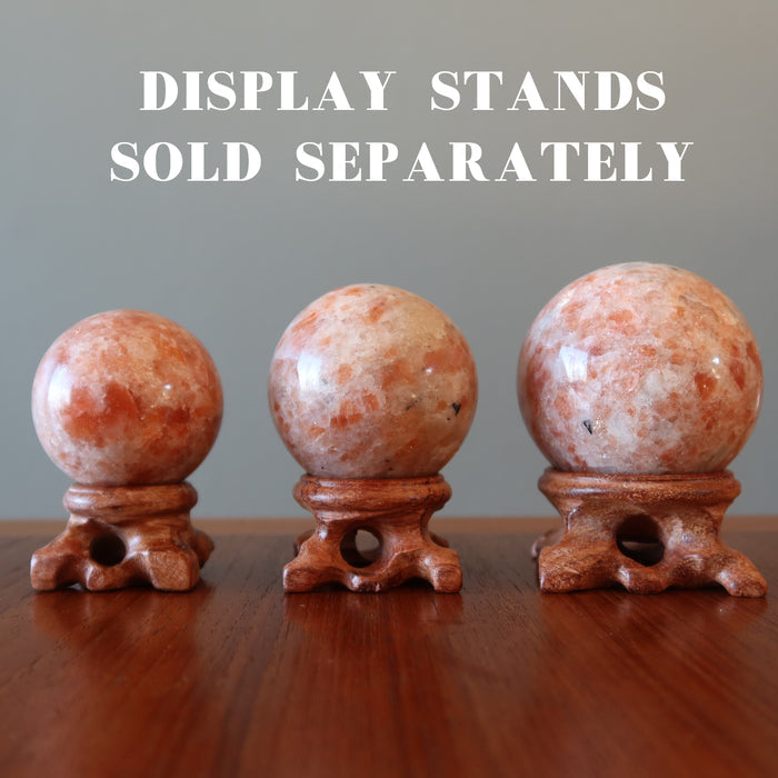 three sunstone spheres on wood display stands, stands sold separately